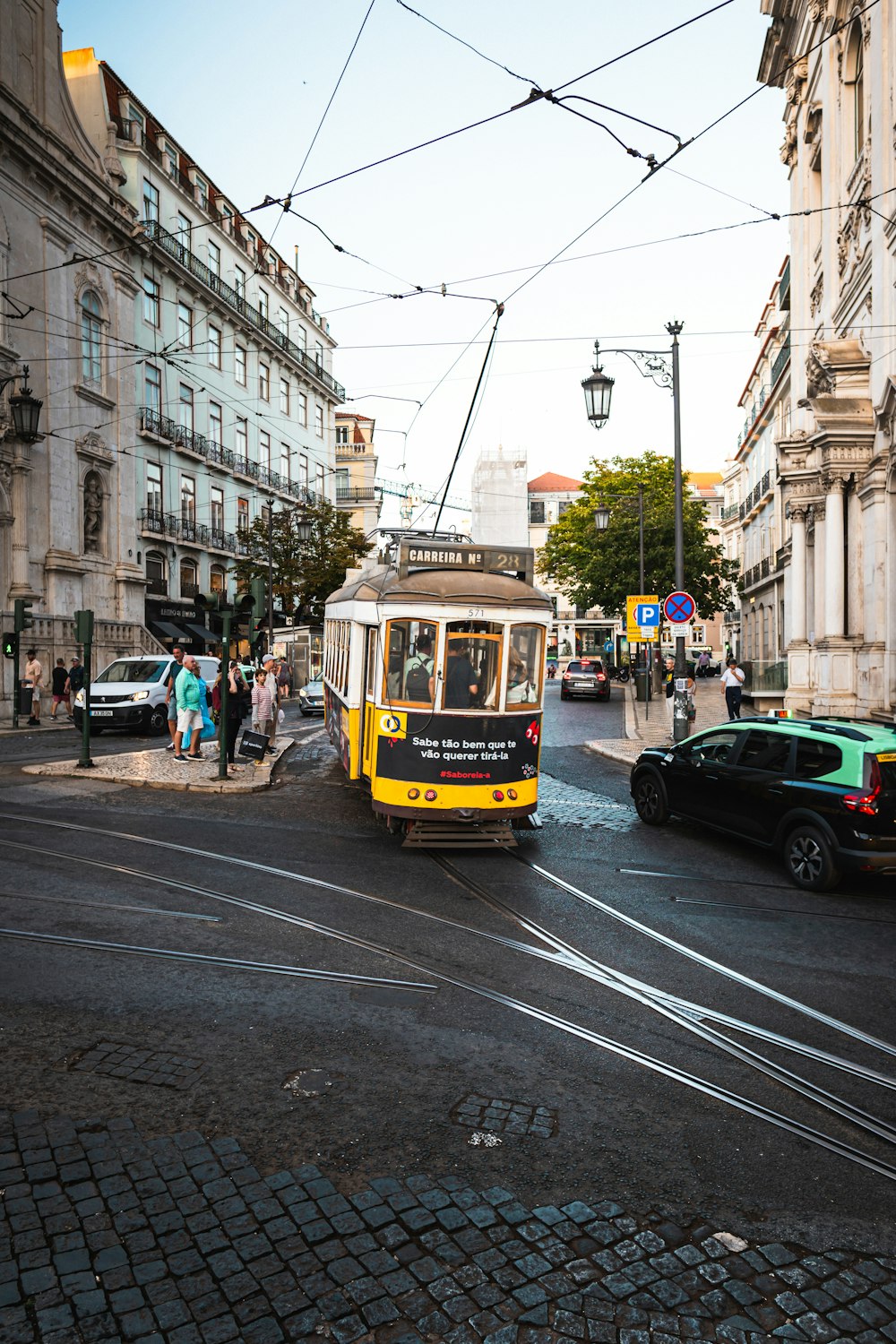 a yellow and black trolley on a city street