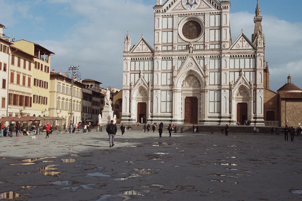 a group of people walking around a city square