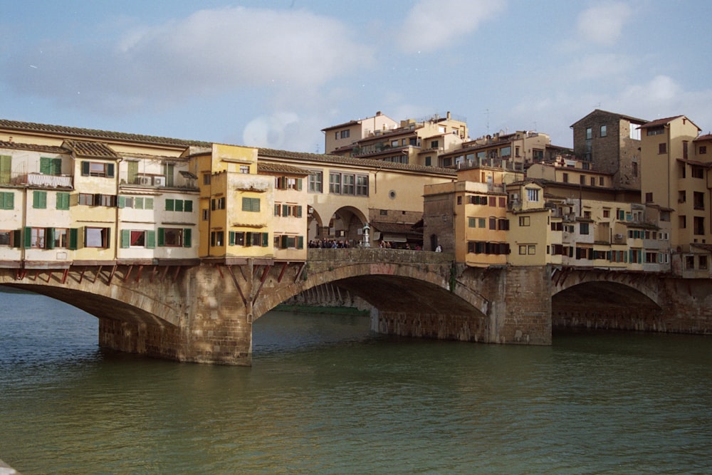 a bridge over a body of water with buildings on top of it