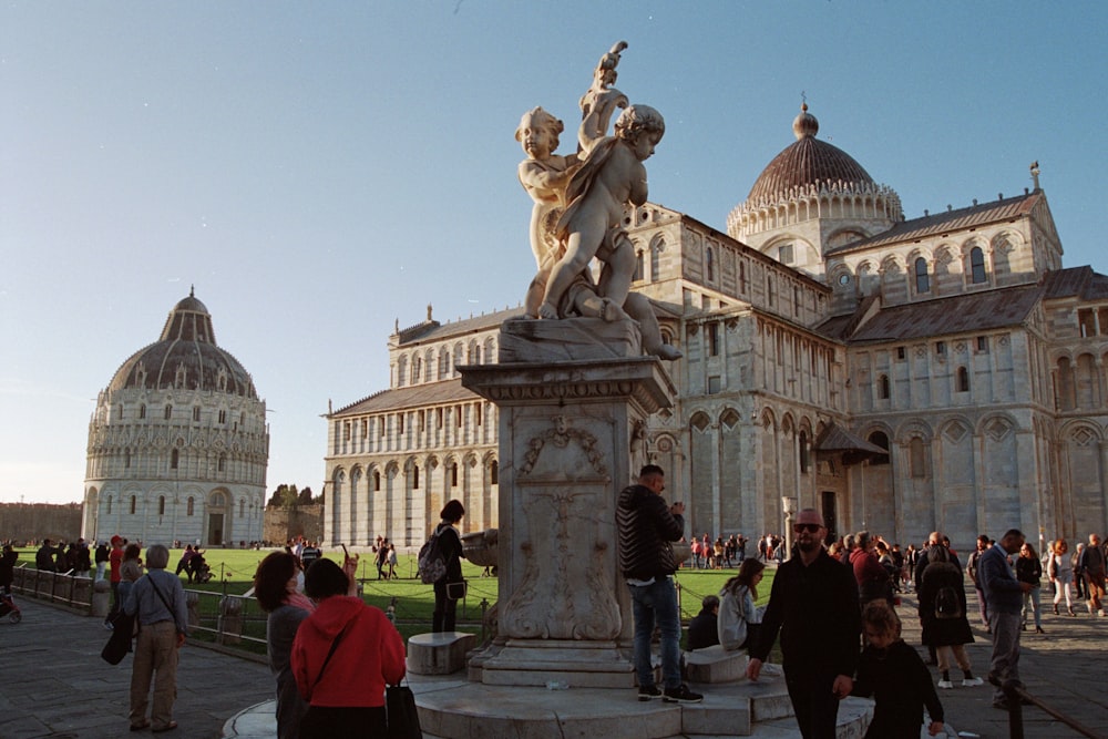 a group of people standing around a statue in front of a building