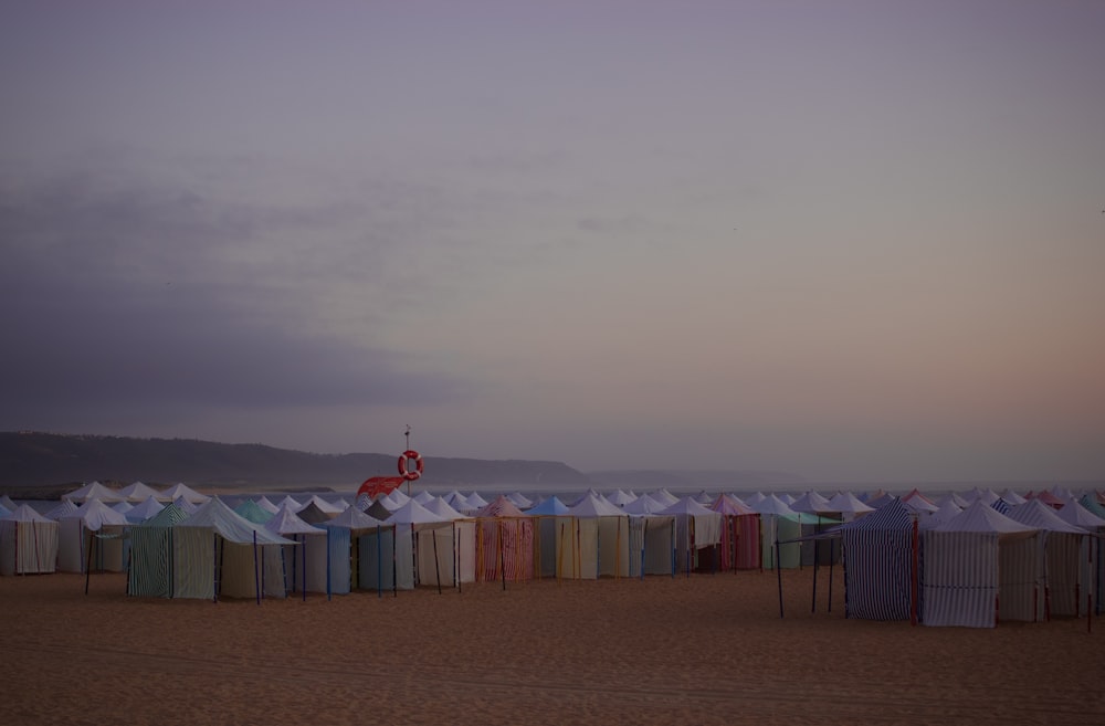 a row of beach huts sitting on top of a sandy beach