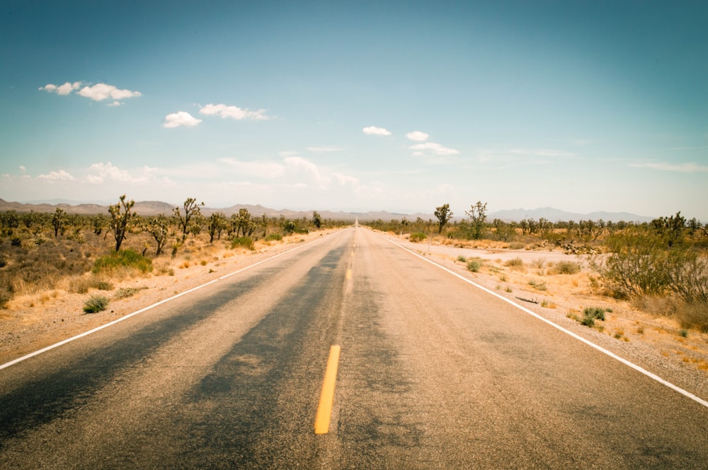 an empty road in the middle of the desert