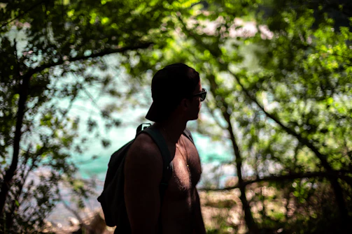 Technical cap with laser-cut ventilation and moisture-wicking fabric perched on a weathered backpack in a forest setting