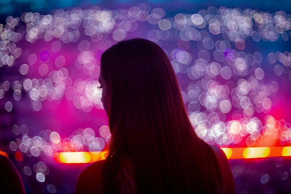 a woman standing in front of a fireworks display