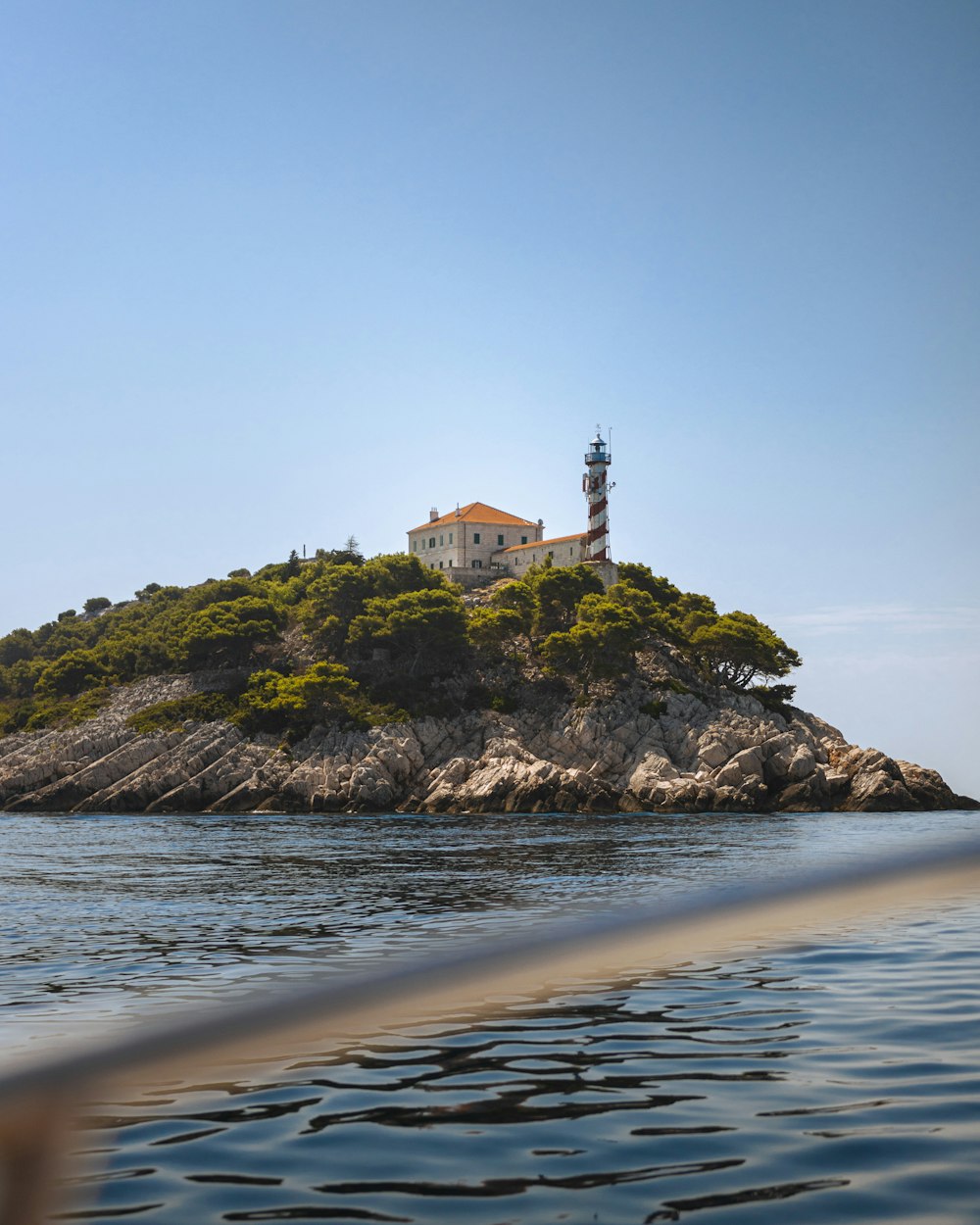 a small island with a lighthouse on top of it