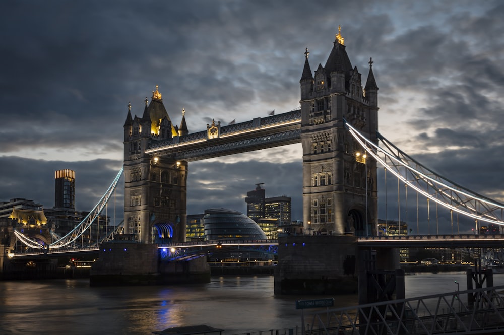 the tower bridge is lit up at night