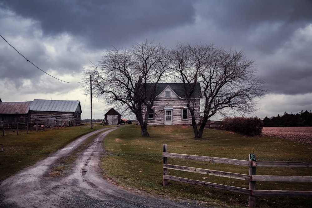 a dirt road leads to an old farm house