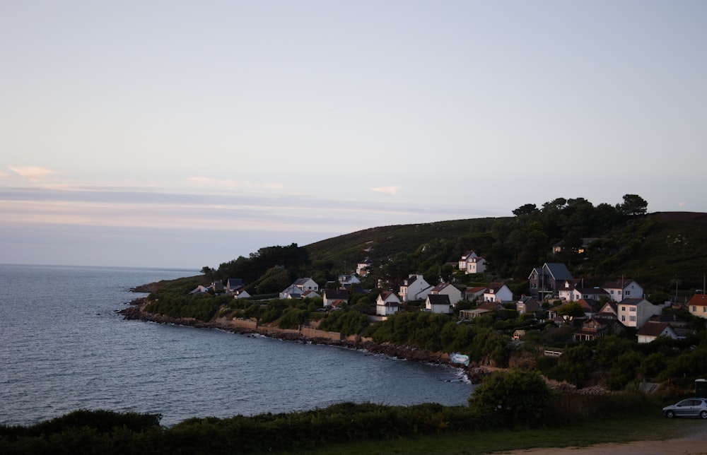 a small town on a hill next to a body of water