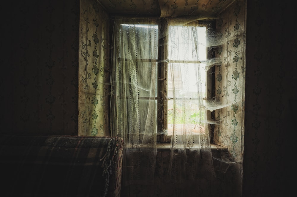 a room with a couch and a curtained window