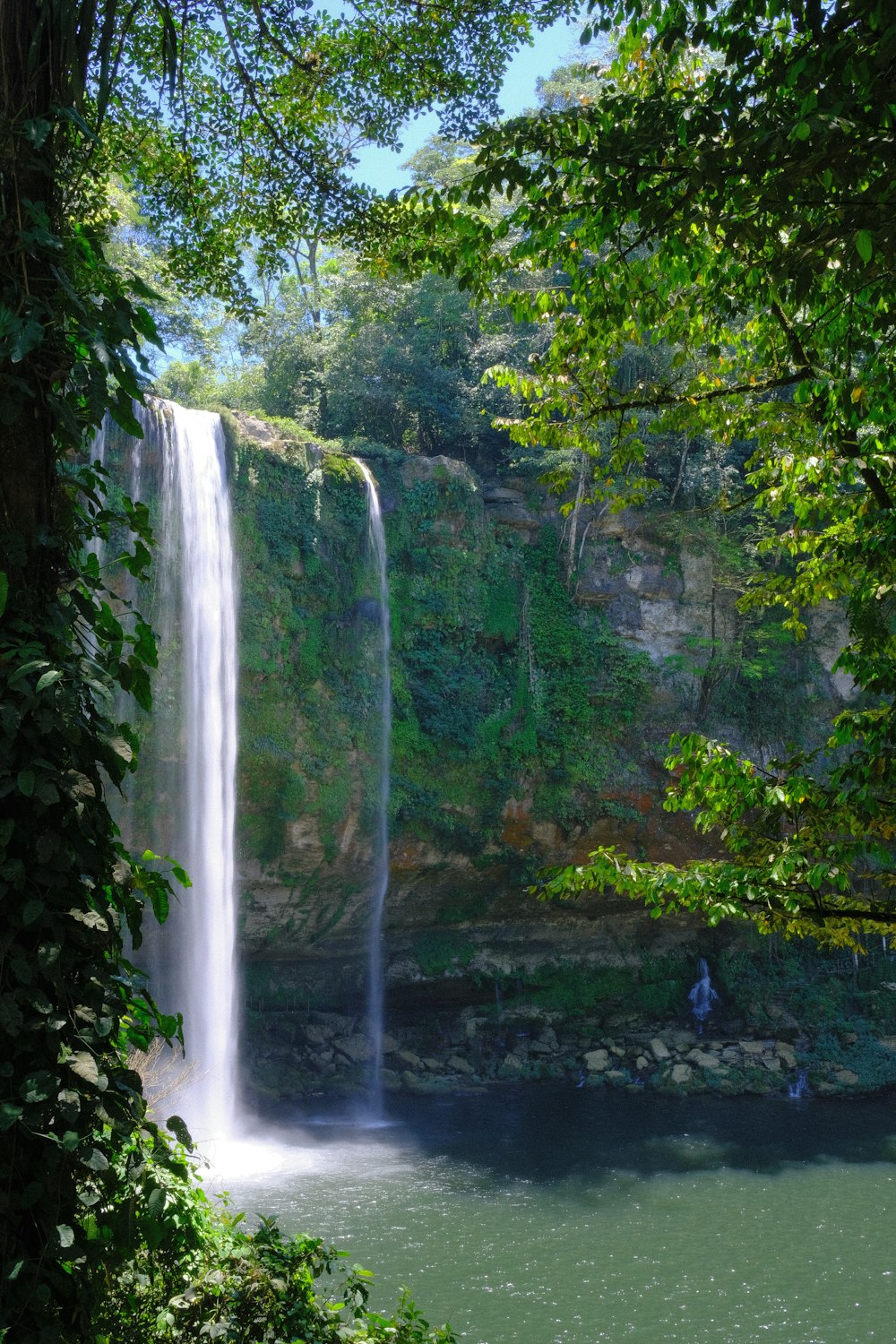 a man standing in front of a waterfall