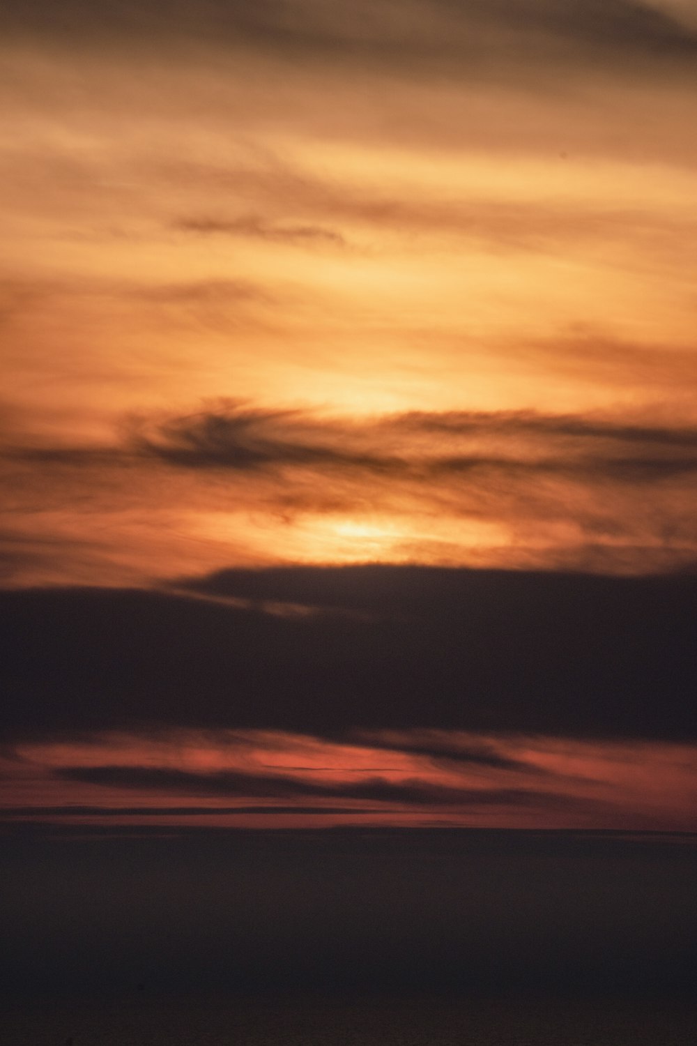 a plane flying in the sky at sunset