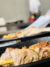 Close-up of marinated meat pieces ready for cooking in a commercial kitchen
