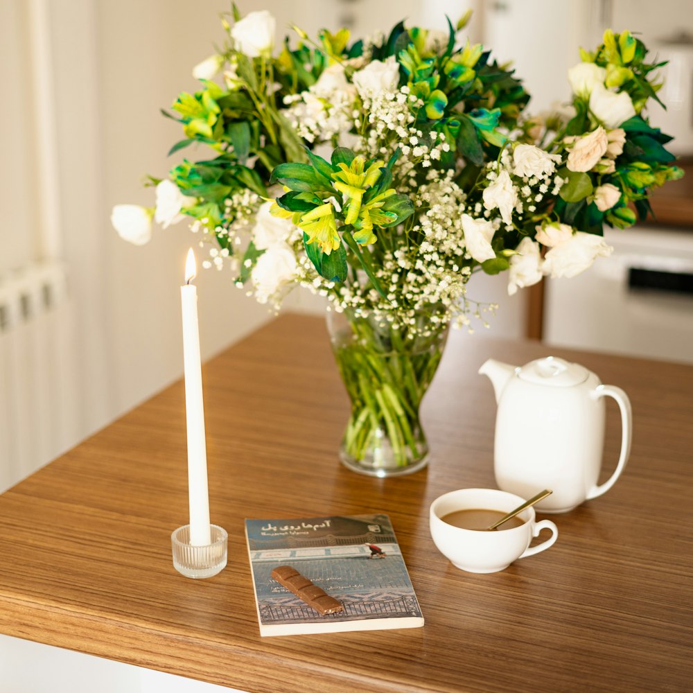 a vase of flowers and a candle on a table