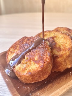 Close-up of golden brown French toast slices dusted with powdered sugar and drizzled with syrup.