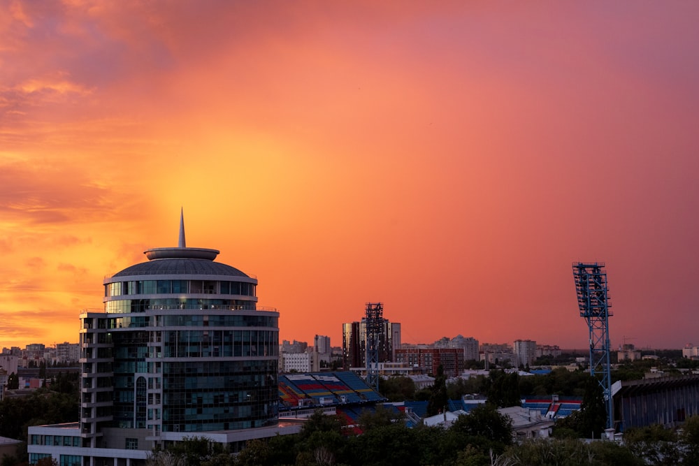 the sun is setting over a city with tall buildings