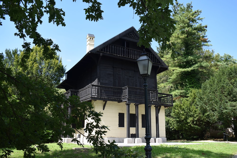 Ein schwarz-weißes Haus mit einem Laternenpfahl