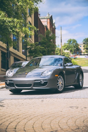 A sleek silver hatchback parked on a sunny urban street, reflecting the vibrant city life around it.