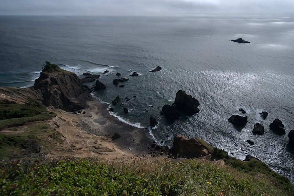 a large body of water sitting next to a lush green hillside