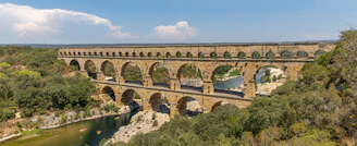an old stone bridge over a river surrounded by trees