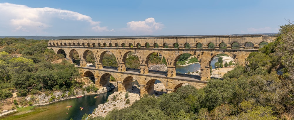 an old stone bridge over a river surrounded by trees