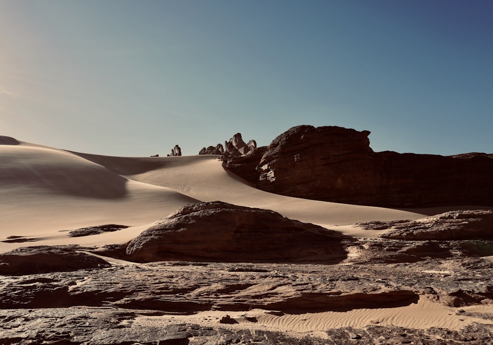 a group of people standing on top of a sandy hill