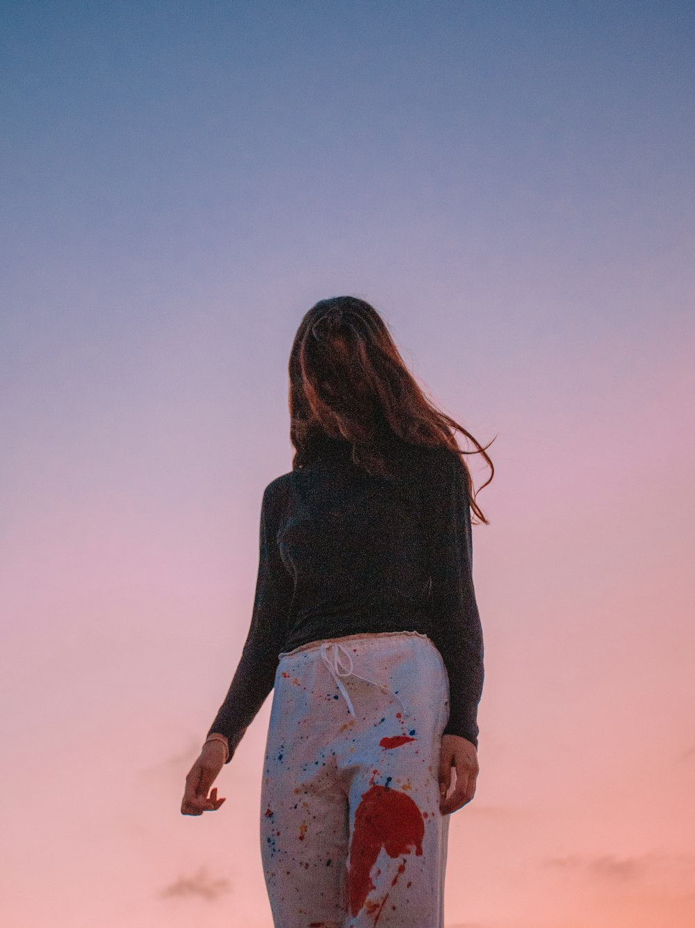 a woman standing on top of a beach next to the ocean