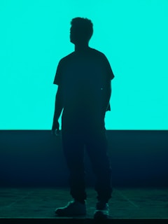 Silhouette of a person standing strong against a dark, moody background.