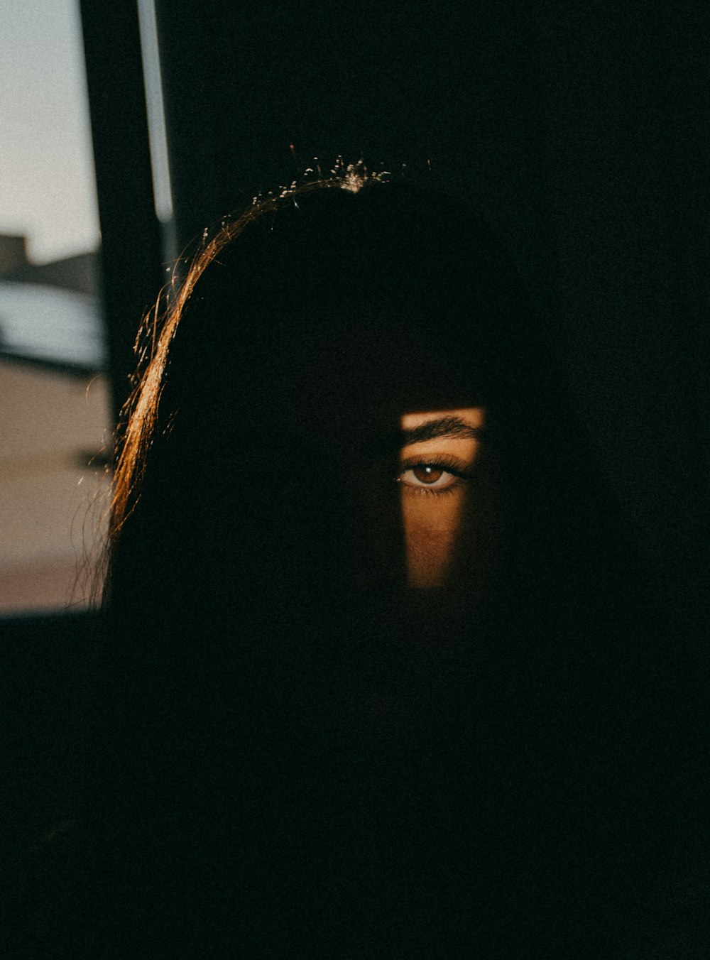 a woman's face is seen through the shadow of a window