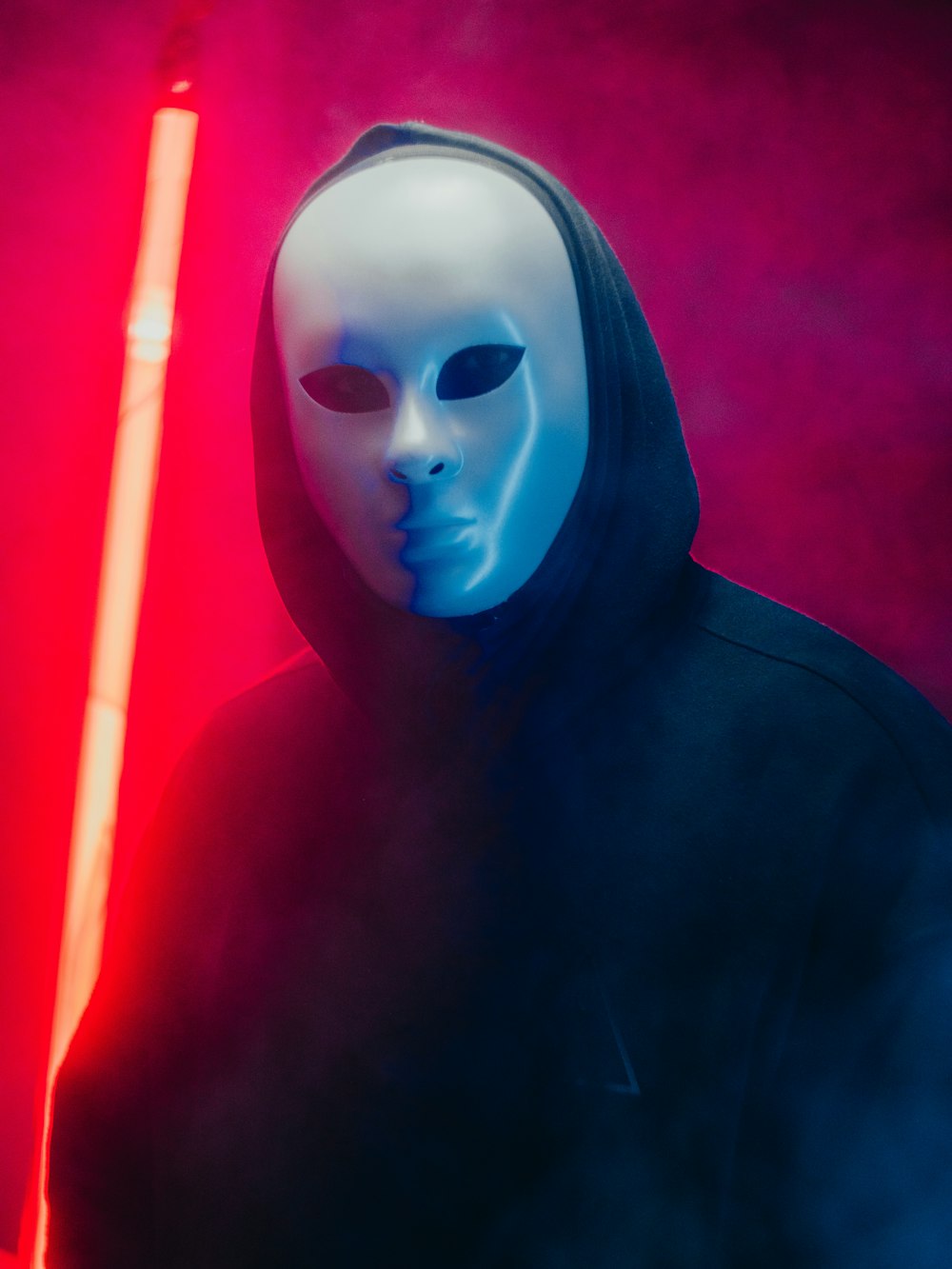 a man wearing a mask and holding a light saber