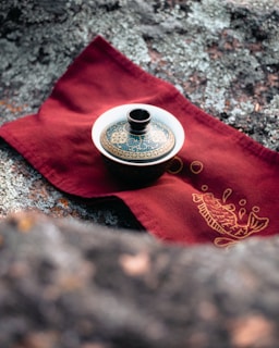 a tea pot sitting on top of a red napkin