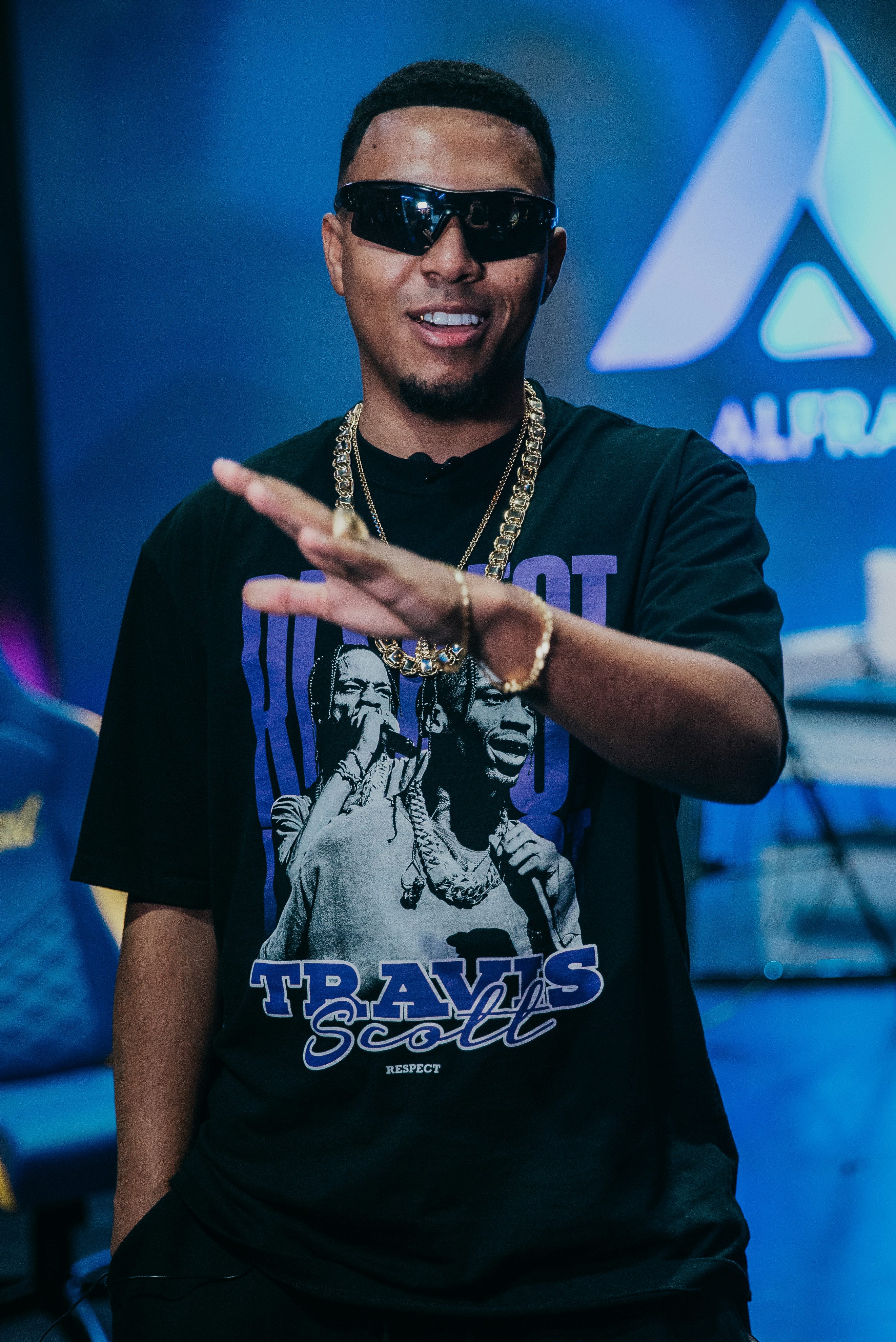 ein mann in schwarzem hemd und sonnenbrille, der eine handbewegung macht