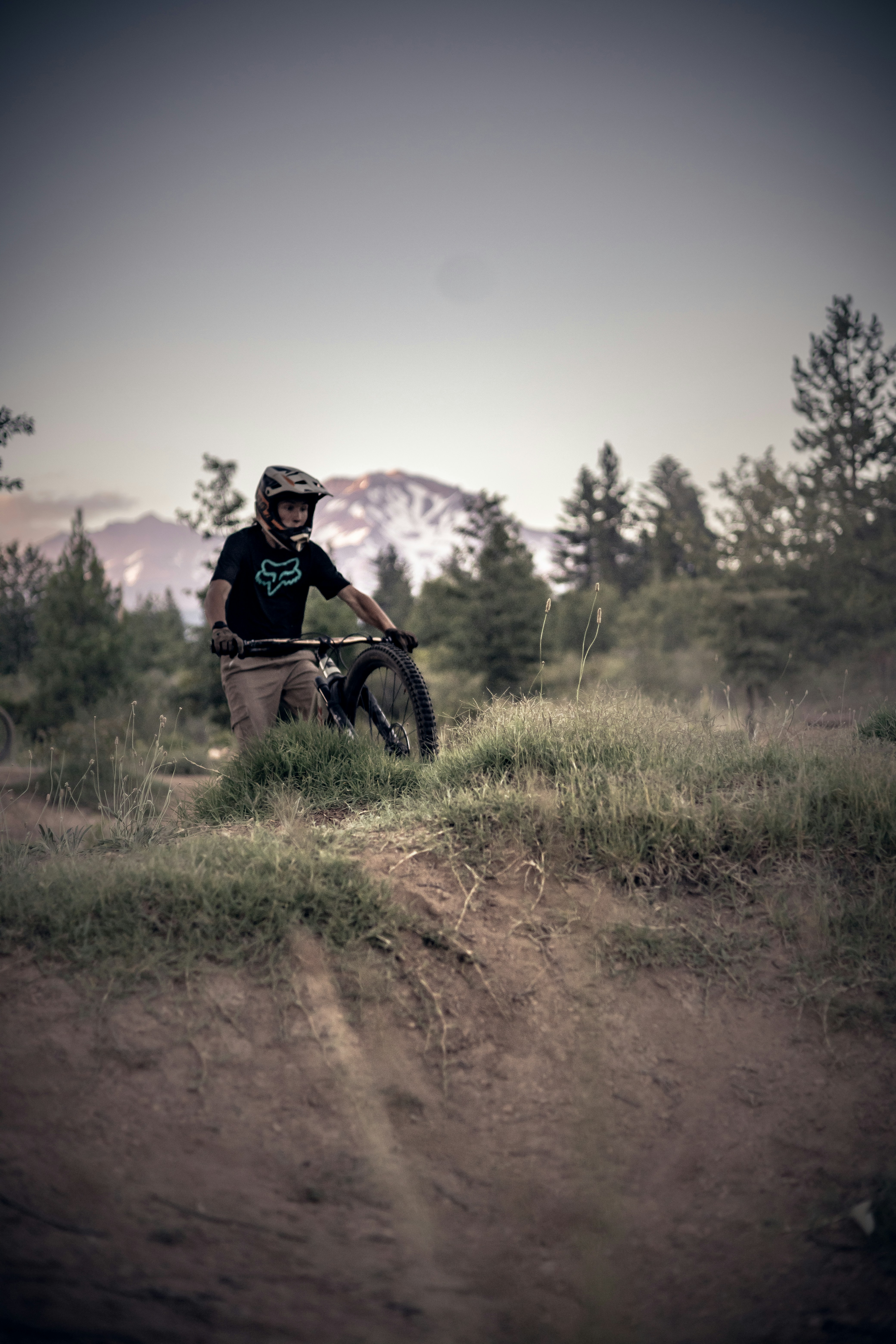 a man riding a bike down a dirt road