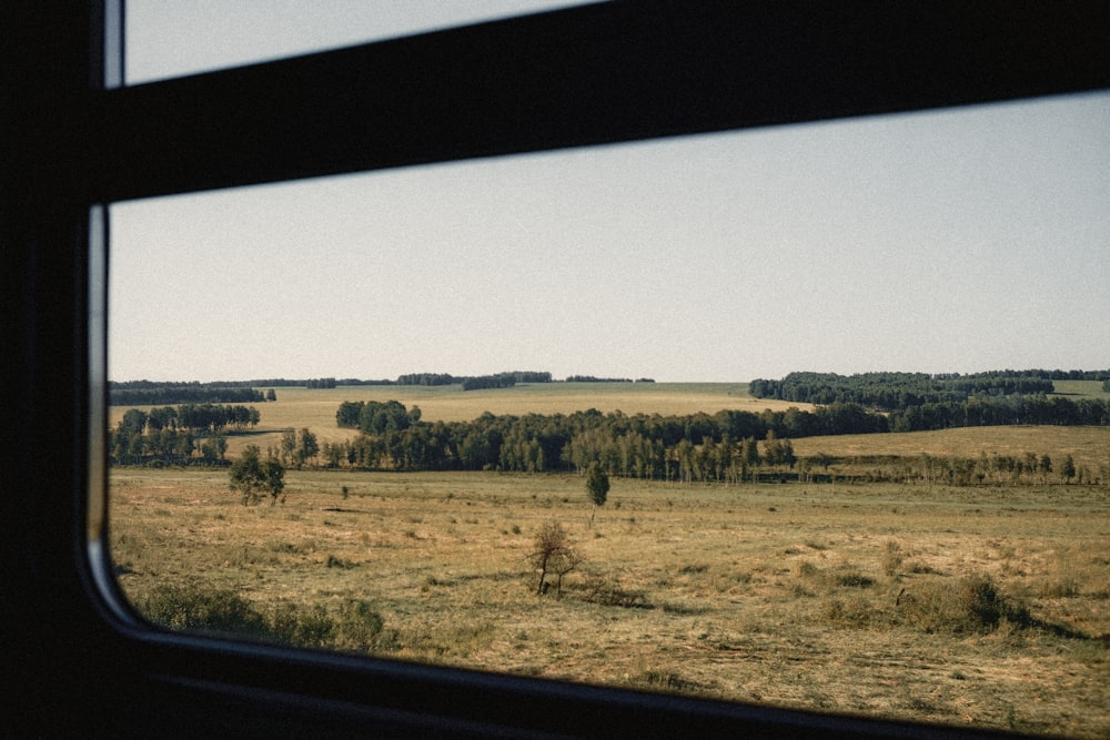 a view of a field from a train window