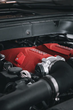 Close-up of a powerful truck engine with metallic and red accents under a dramatic light.