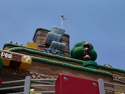 Bright pastel blocks stacked like Minecraft creations with cute gaming icons floating around.