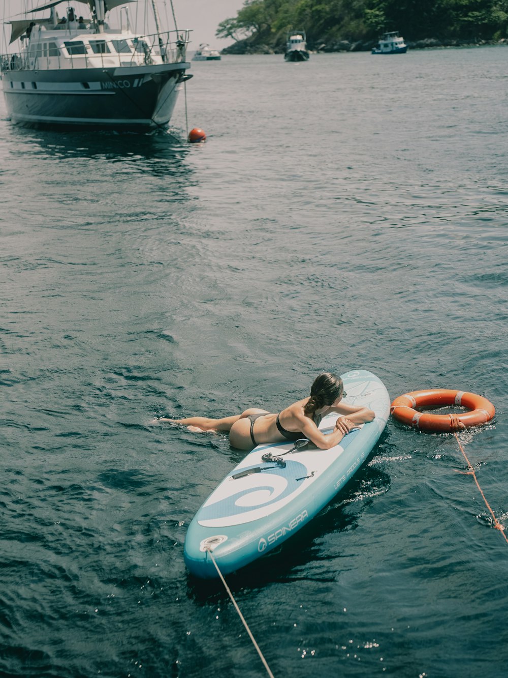 a woman laying on a surfboard in the water