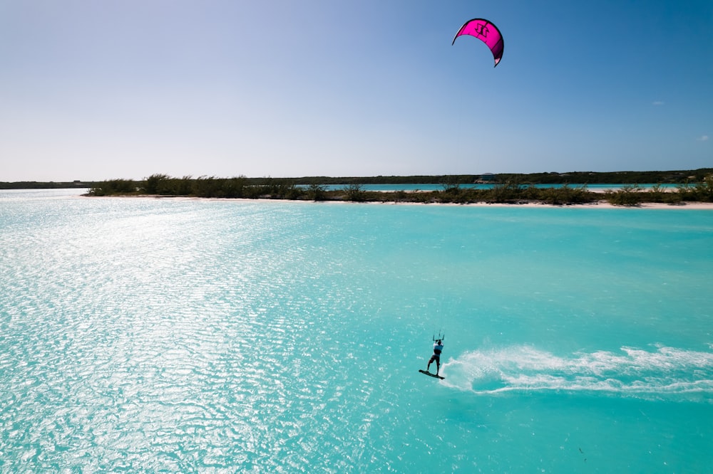 a person is para sailing in the blue water