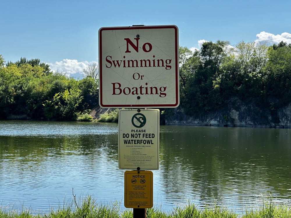 a no swimming or boating sign next to a lake