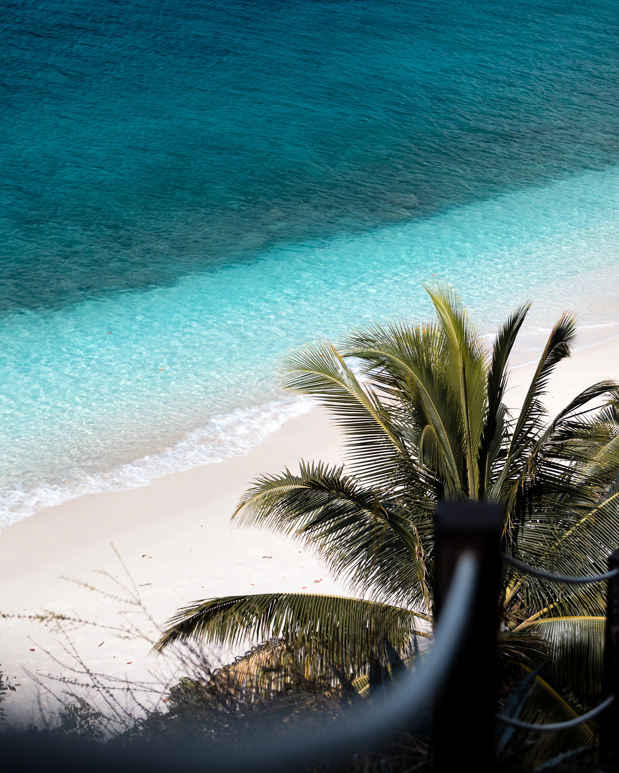Terrace view over a turquoise white-sand Caribbean cove