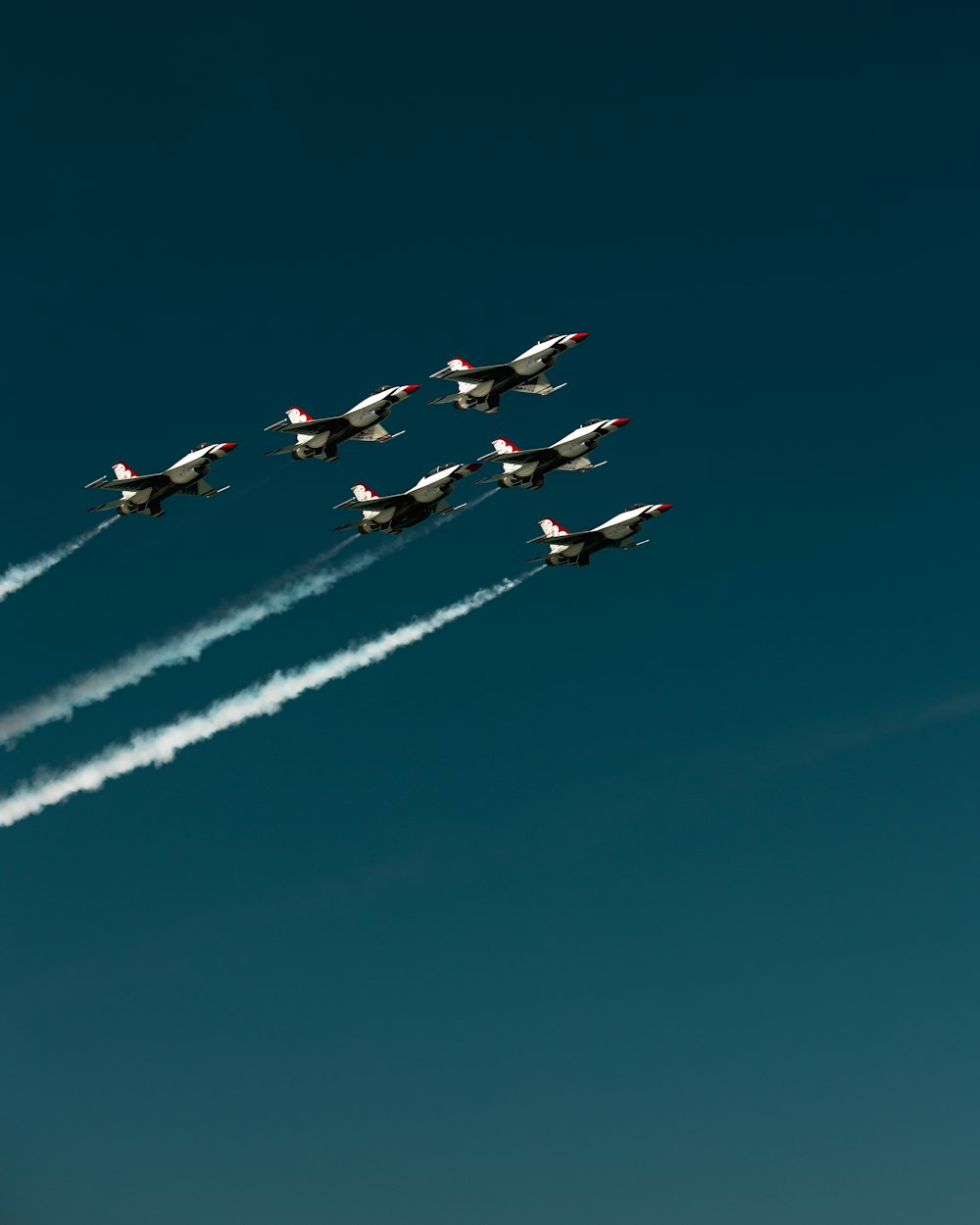 a group of airplanes flying through a blue sky