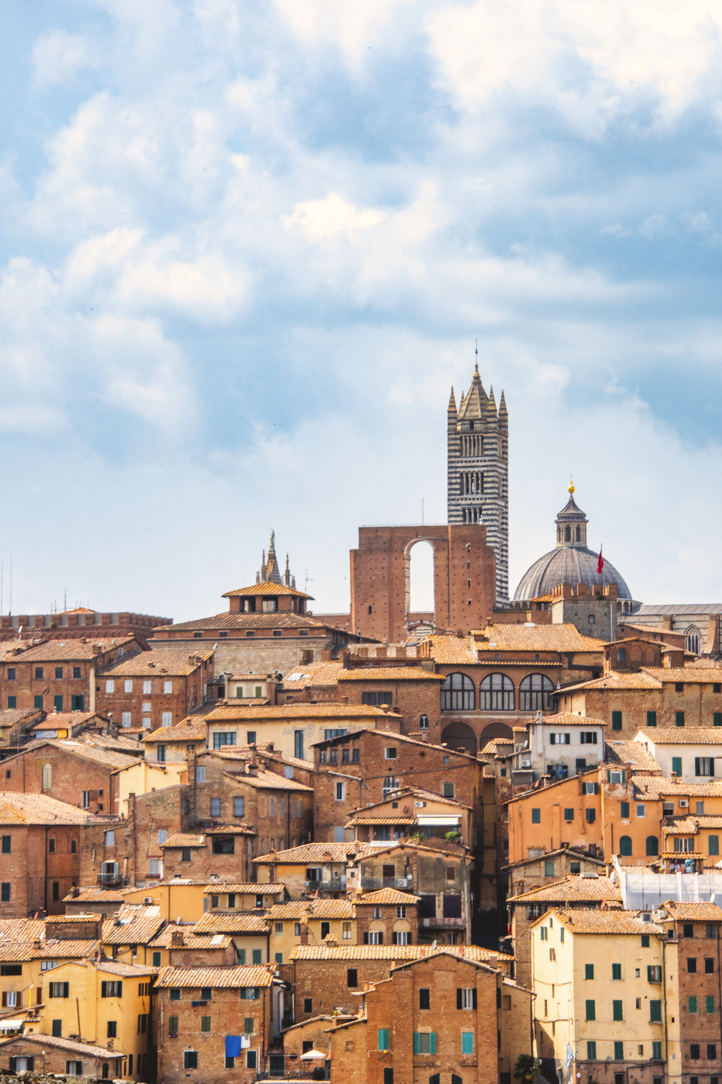 Warme terracotta daken van Siena met de Duomo op de achtergrond