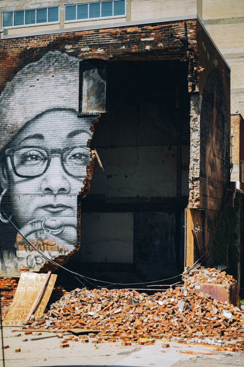 une peinture murale d’un homme avec des lunettes sur un bâtiment
