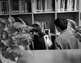 a couple of people that are looking at a book