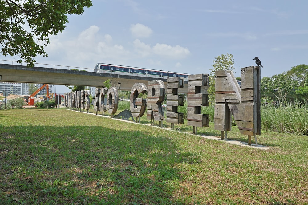 a train traveling over a bridge over a lush green field