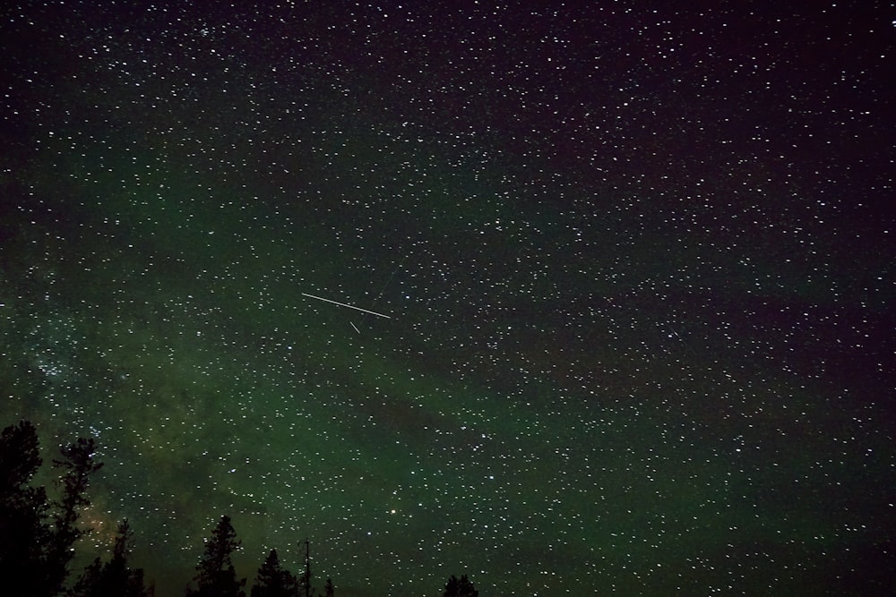 a night sky with stars and a shooting star