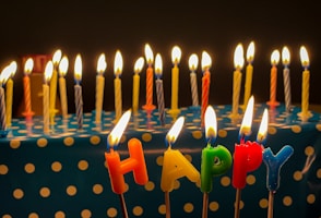 a birthday cake with candles that spell out happy