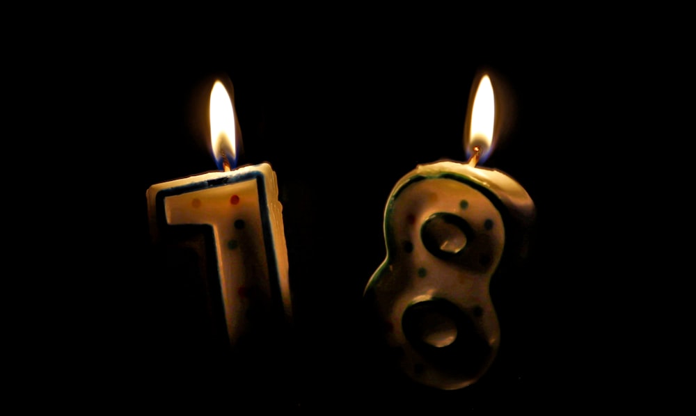 two candles are lit in the shape of numbers