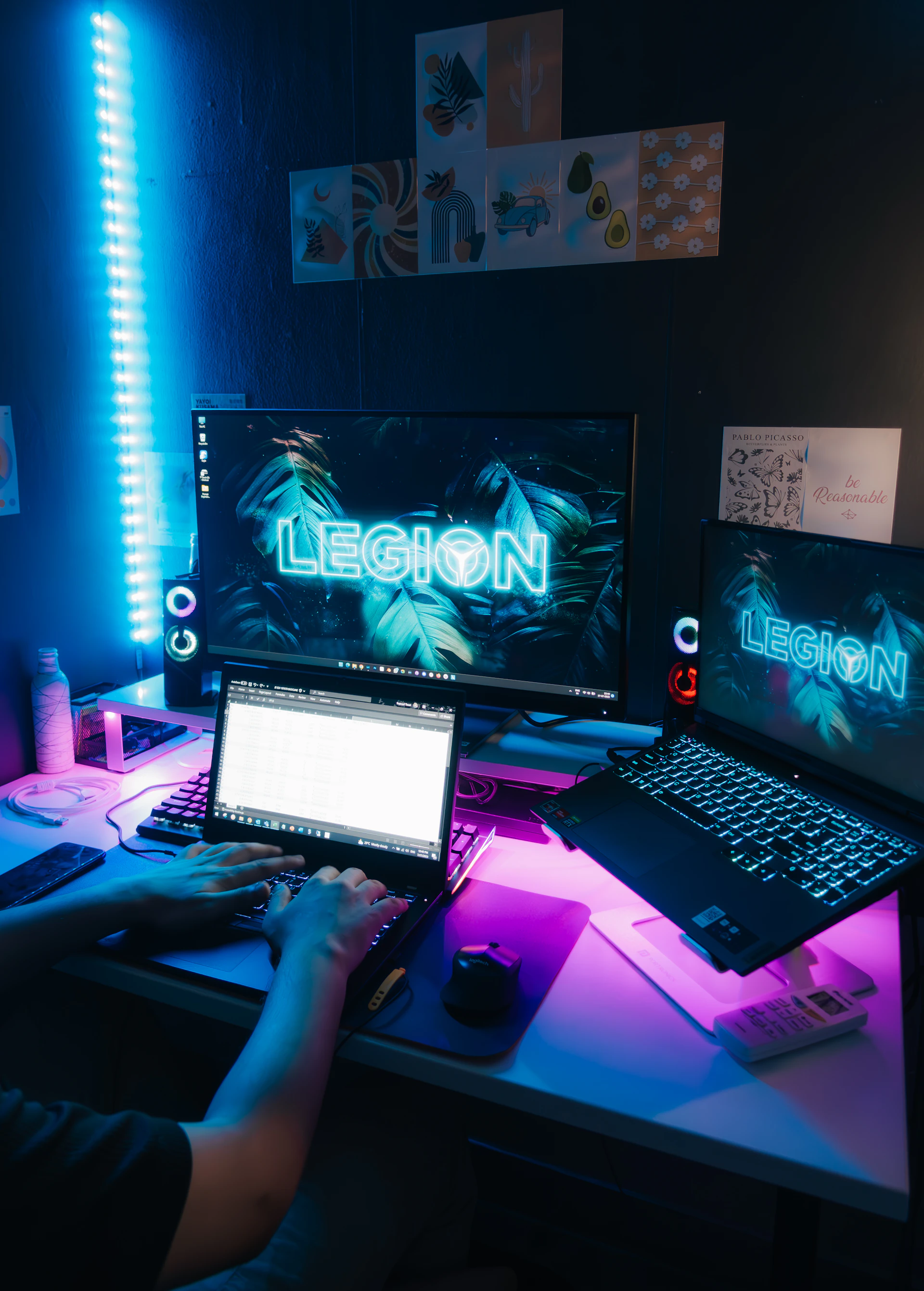 a person sitting at a desk with a laptop and a monitor