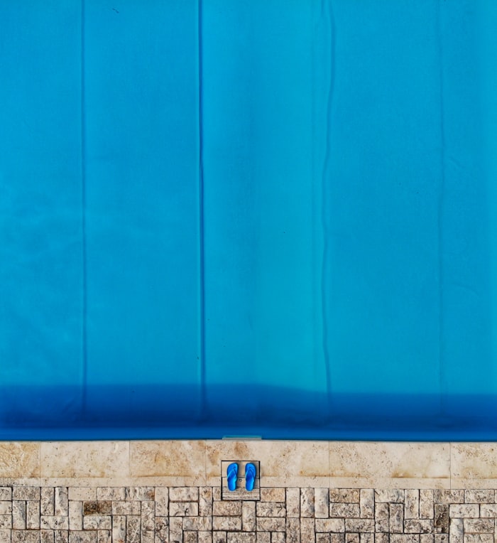 Pool covered under a tarp with cloudy water beneath after months of winter closure