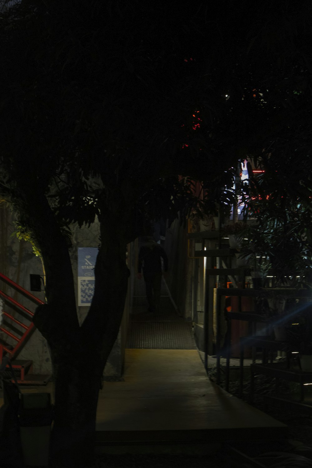 a person walking down a sidewalk at night